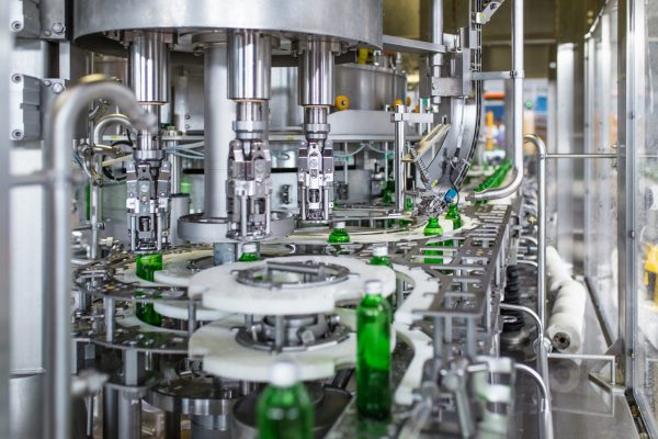 Bottling plant - Water bottling line for processing and bottling pure spring water into green glass bottles. Selective focus.