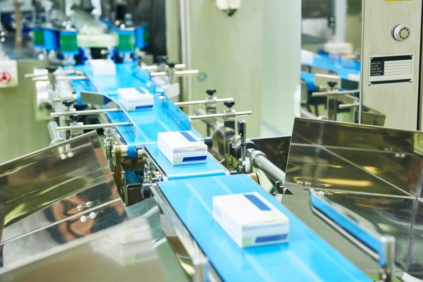 pharmaceutical packing production line conveyer at manufacture pharmacy factory. Authentic shot in challenging conditions. maybe little blurred